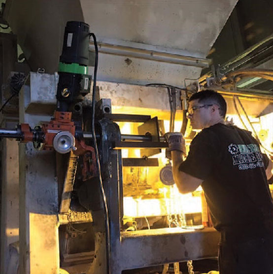 Technician working on industrial machinery, representing Heritage Machine Group's precision machining and fabrication services for steel mills, power plants, and paper mills.